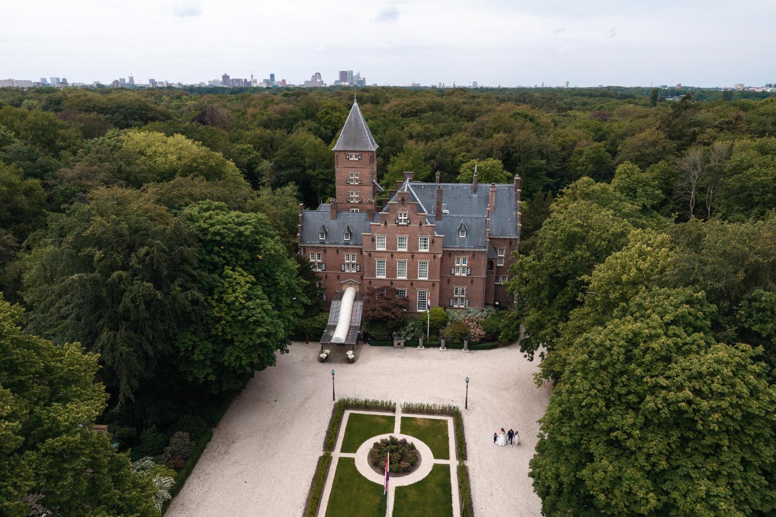 Luchtfoto van Kasteel de Wittenburg in Wassenaar waarop George, Iris en hun kinderen samen over het groene landgoed wandelen.
