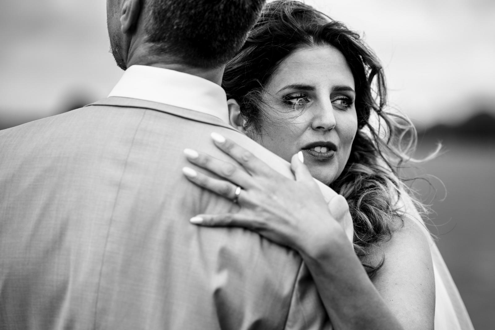 Close-up zwart-wit portret van Chantal die haar armen om Gerrit slaat, een emotioneel en liefdevol moment.