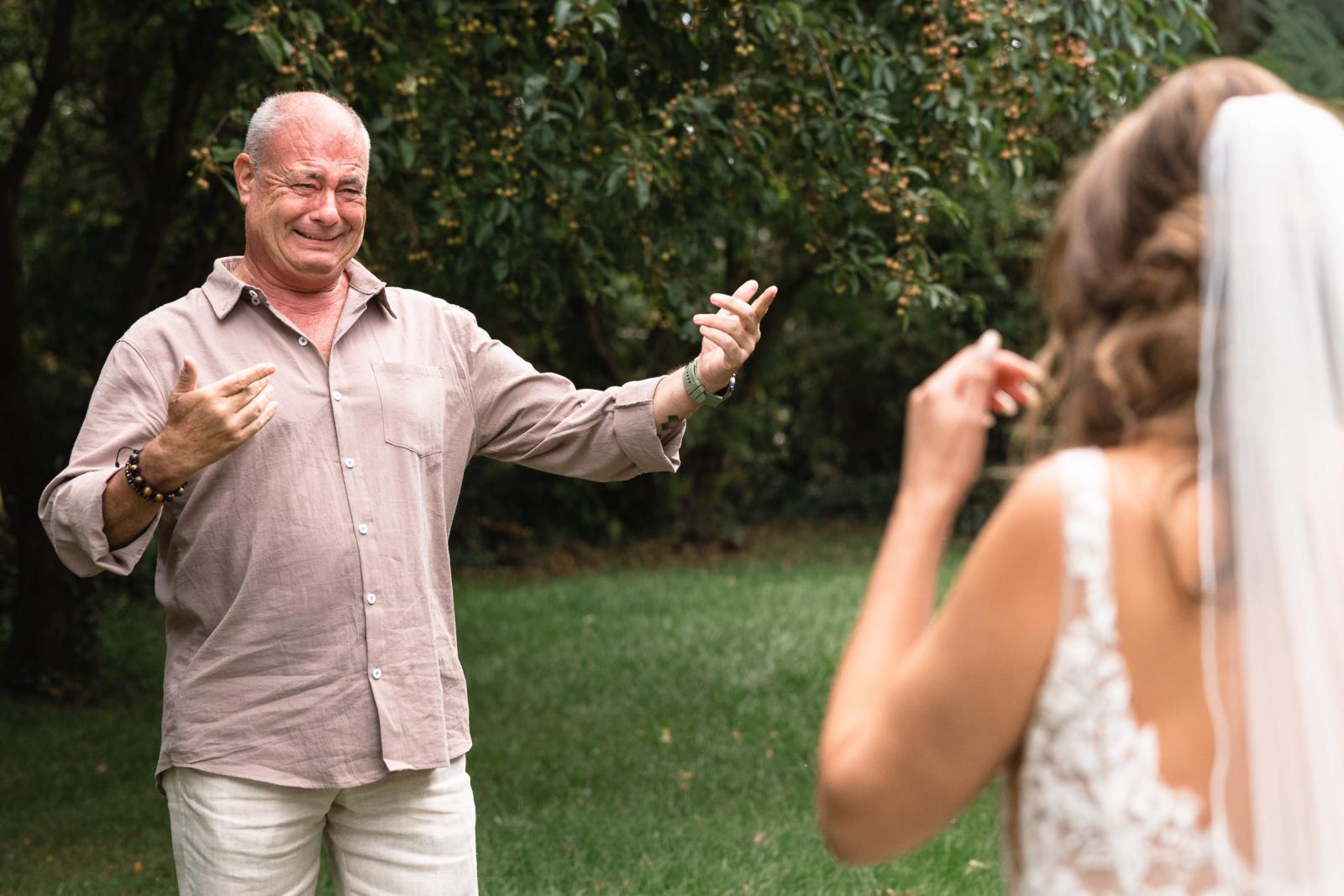 Emotionele vader ziet zijn dochter in trouwjurk voor het eerst en opent zijn armen.