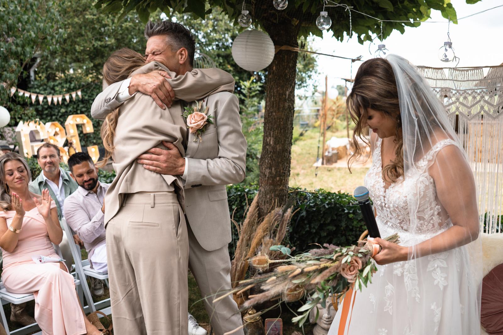 Bruidegom omhelst dochter tijdens de trouwceremonie