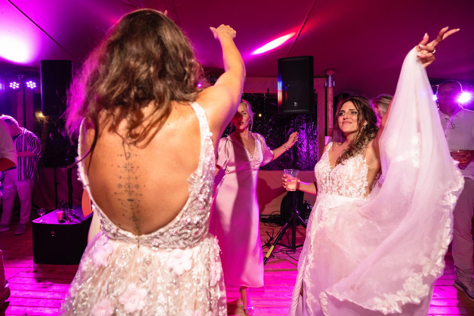 De bruid lacht terwijl ze danst met vrienden en familie tijdens het avondfeest.