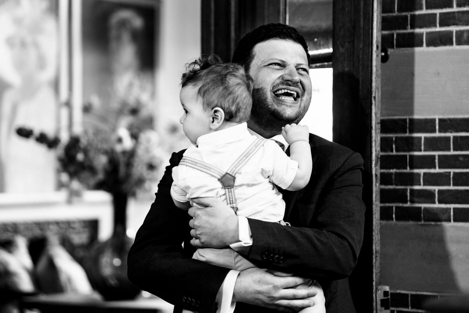 Lachende bruidegom Dennis houdt een baby vast voor de ontmoeting met bruid Hanneke.