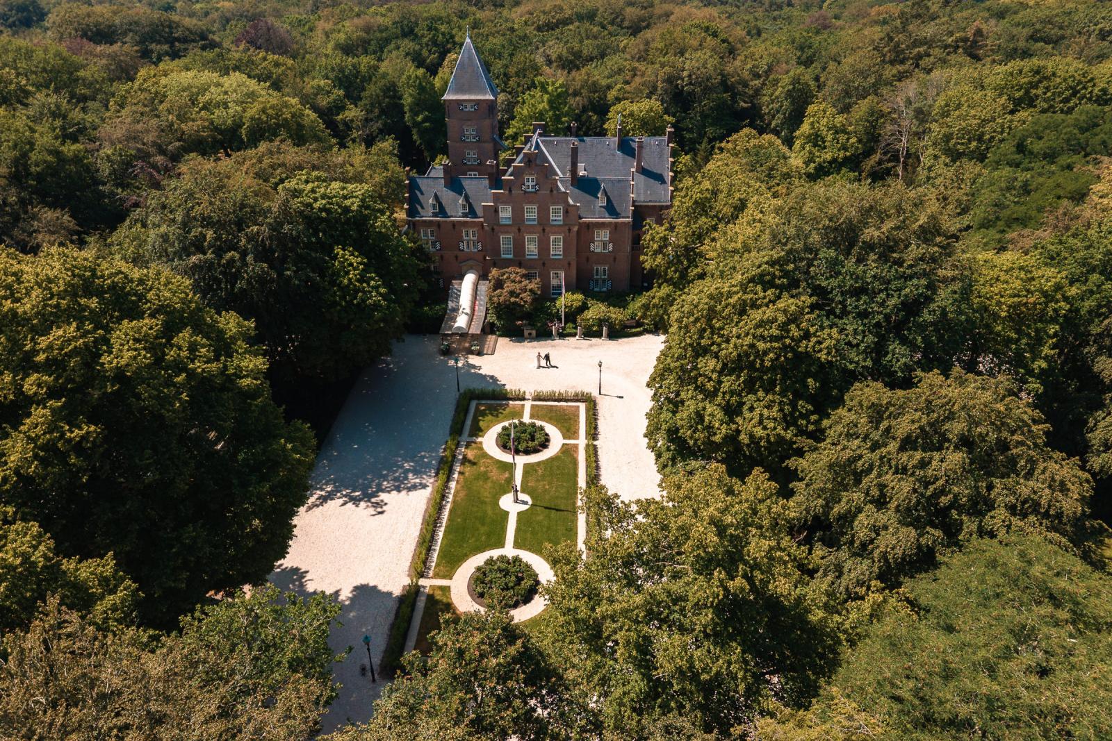Luchtfoto (luchtopname) van het historische landgoed en de kasteeltuin waar de bruiloft plaatsvindt.