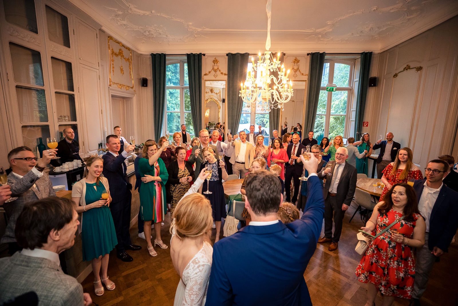Proost moment bruidspaar en gasten trouwceremonie Spaansche Hof Den Haag