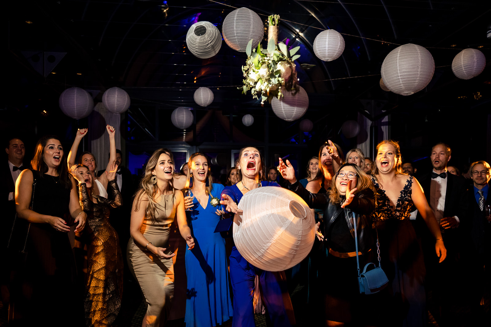 Bruid gooit een van de lampionnen eraf tijdens het boeket gooi moment Trouwfotograaf Den Haag 