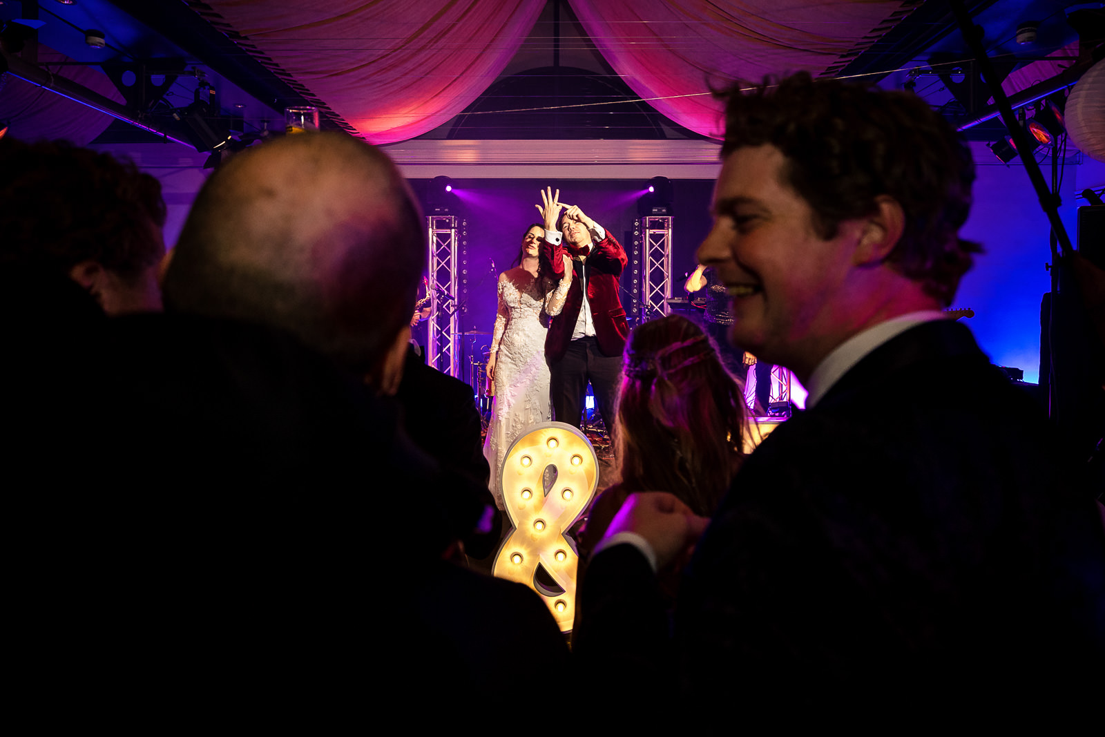 Huwelijks feest bruid en bruidegom op podium met de band Trouwfotograaf Den Haag 