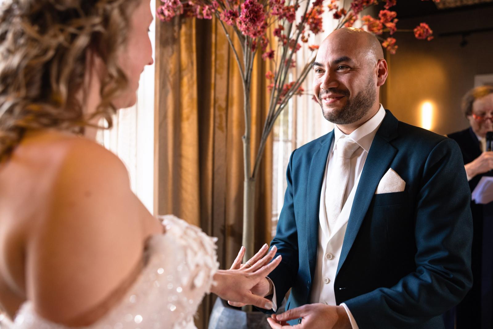 Een intieme close-up van Judith en Mark direct na de ringenoverdracht, waarbij ze elkaar gelukkig en glimlachend aankijken.