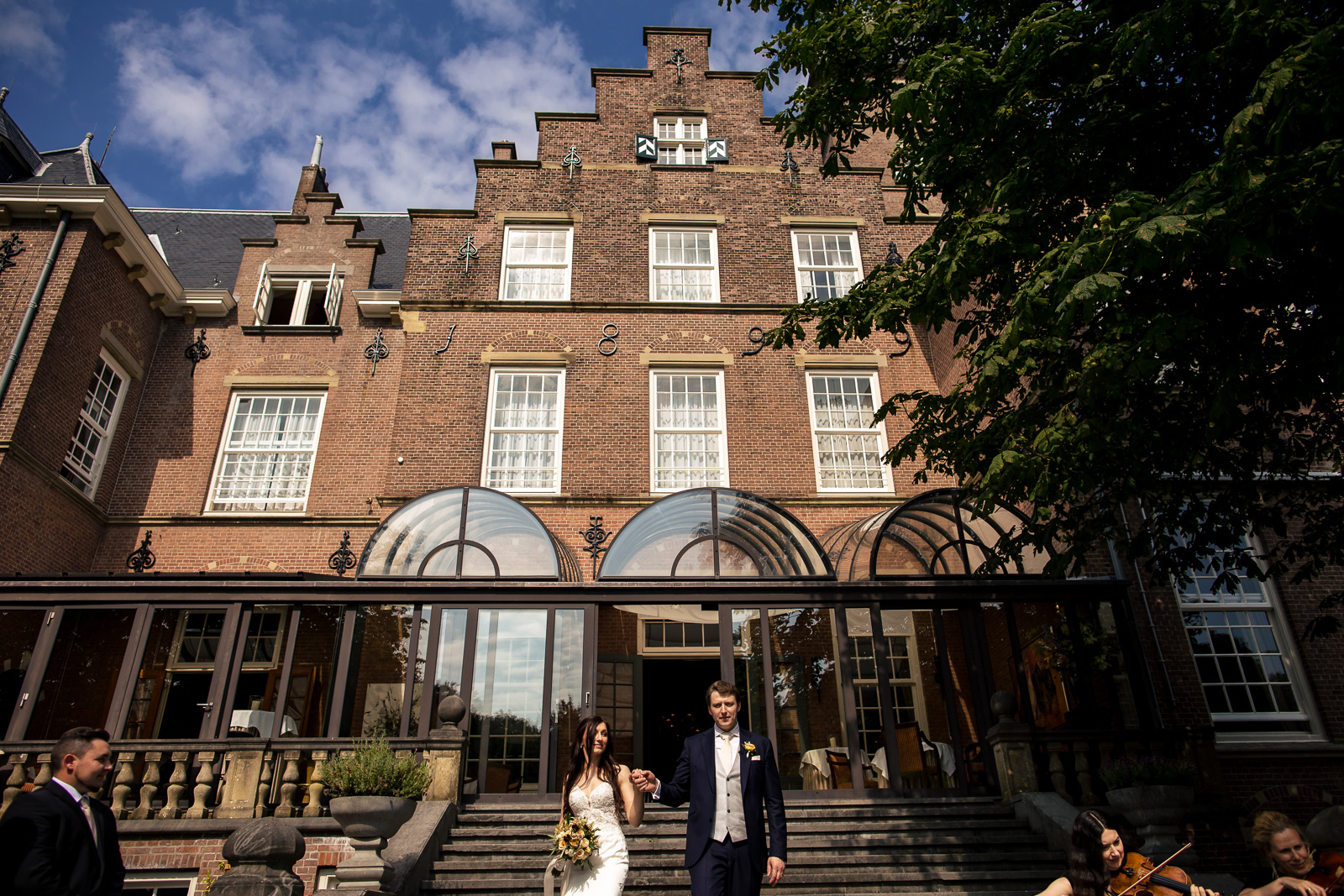 Entree bruidspaar in de kasteel tuin door kasteel trouwfotograaf