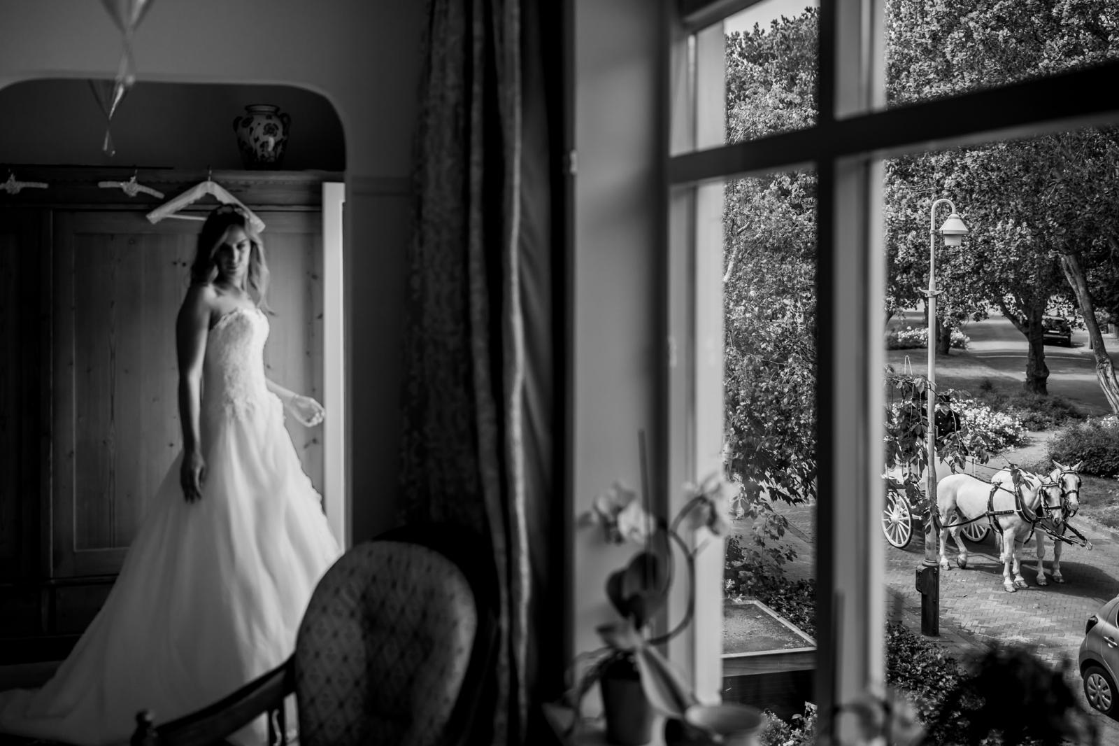 Bruid kijkt naar trouwkoets