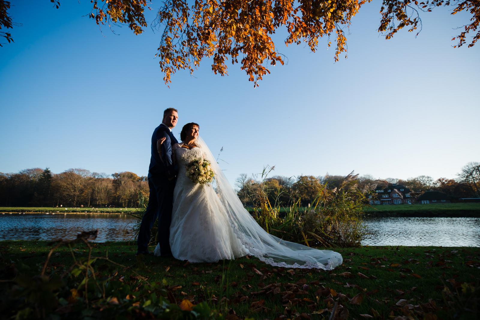 bruidspaar kijkt naar zonsondergang tijdens de herfst shoot bij kasteel oud wassenaar