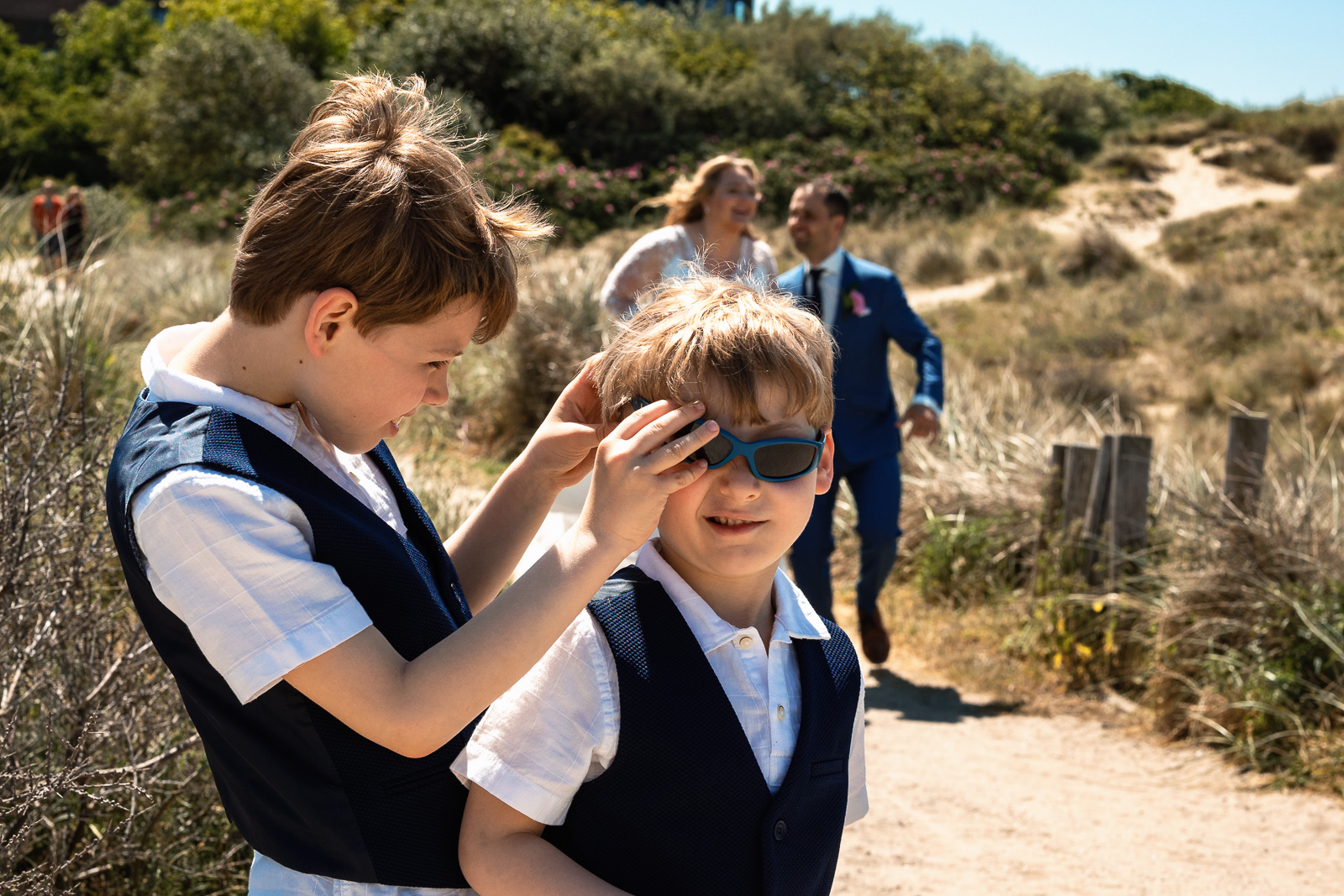 Kinderen bruidspaar stoeien om bril op de voorgrond Trouwfotograaf Spaansche Hof Den Haag