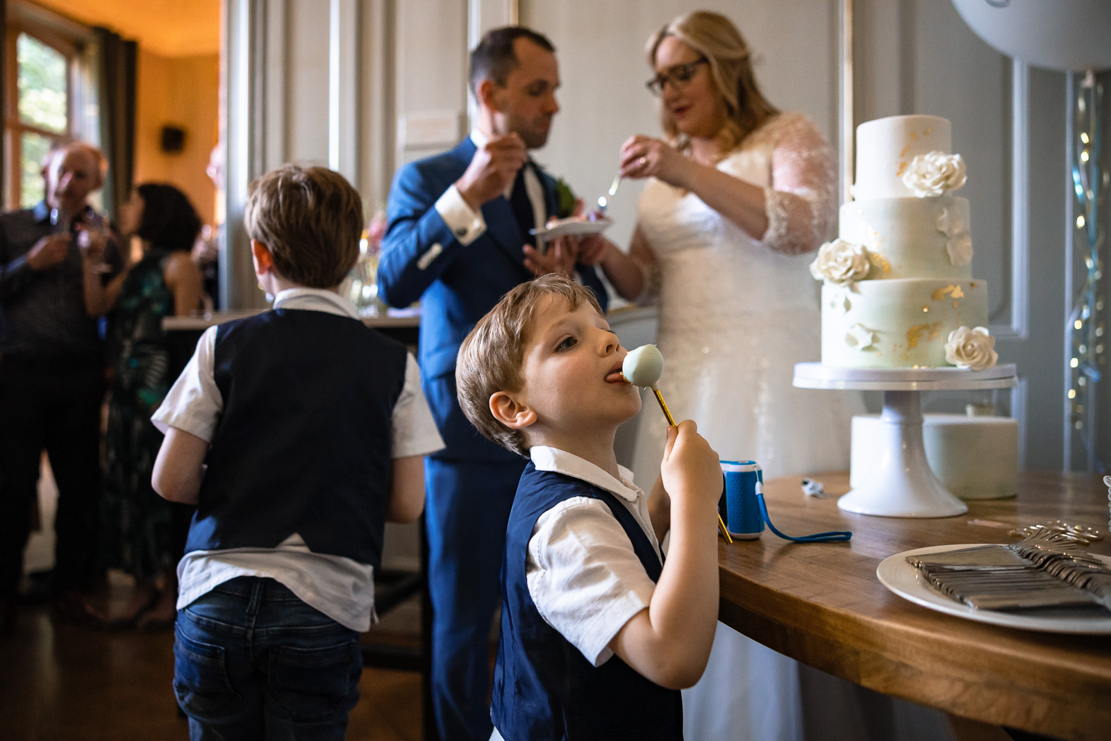 taart moment bruidspaar terwijl hun zoon als iets lekkers eet Trouwfotograaf Spaansche Hof Den Haag