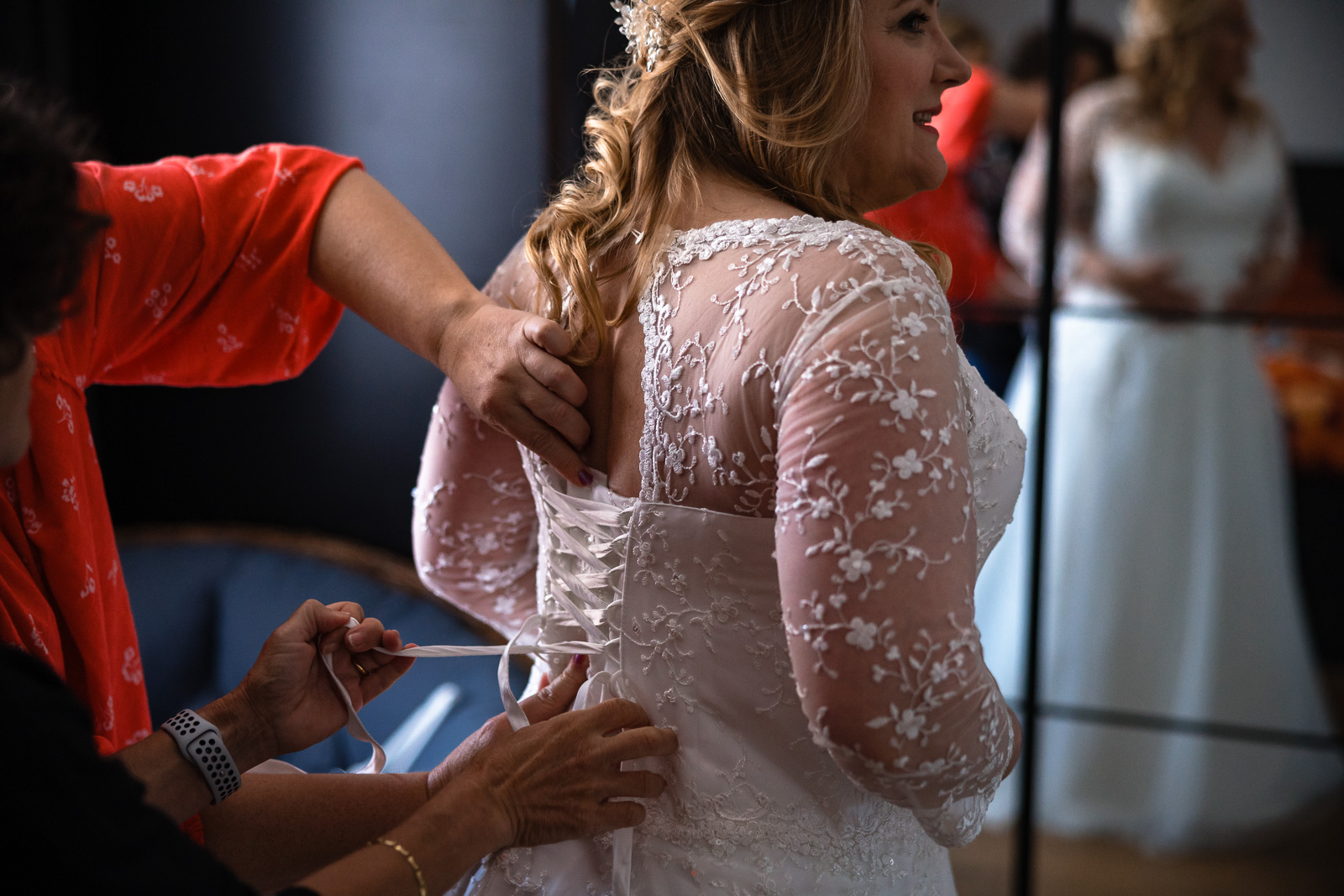 Bruid krijgt hulp met trouwjurk dicht doen Trouwfotograaf Spaansche Hof Den Haag