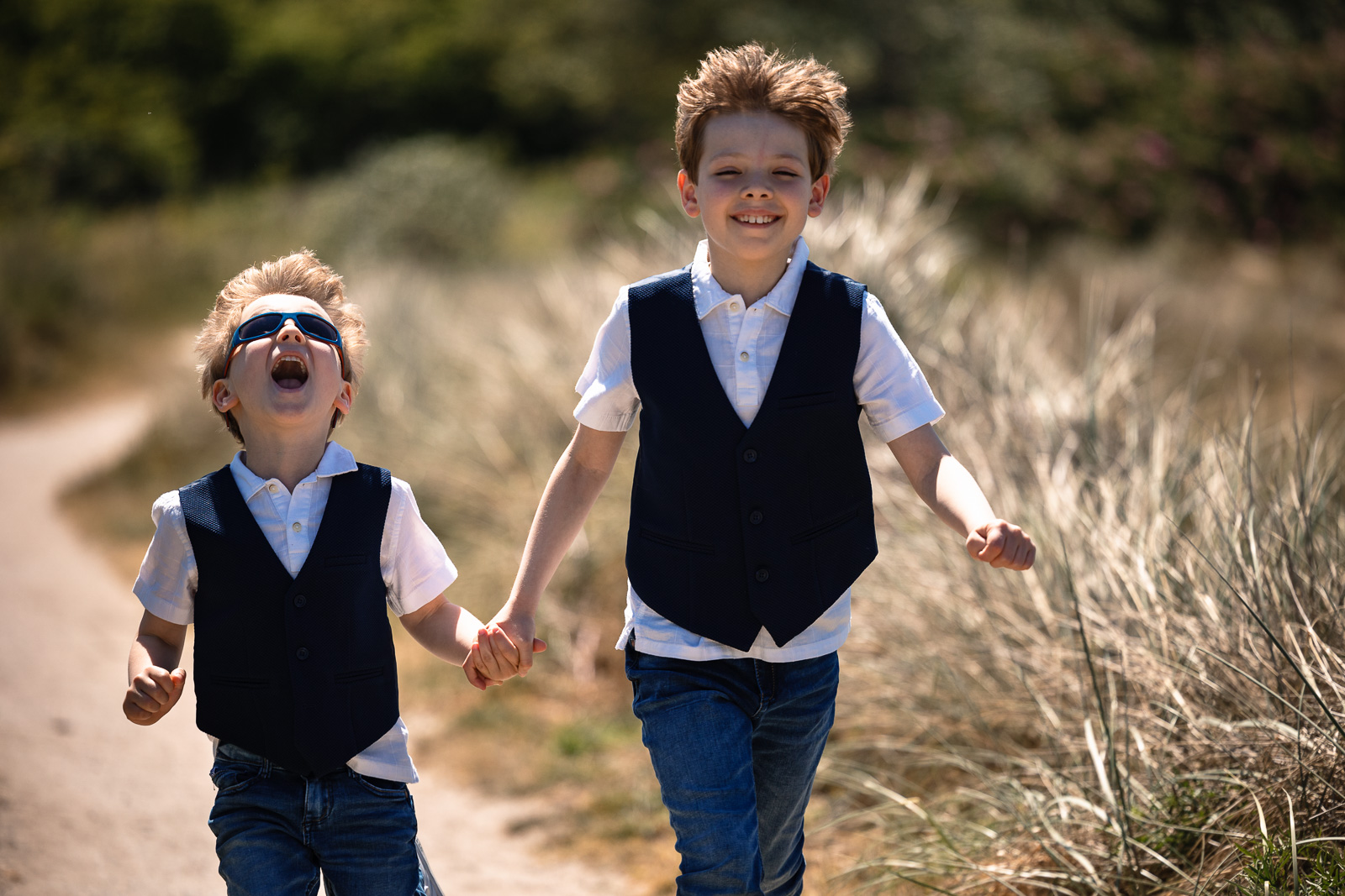 kinderen van het bruidspaar rennen in de duinen Trouwfotograaf Spaansche Hof Den Haag