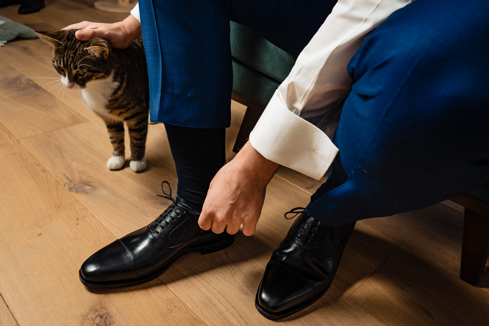 Trouwfotograaf Leiden bruidegom doet trouwschoenen aan