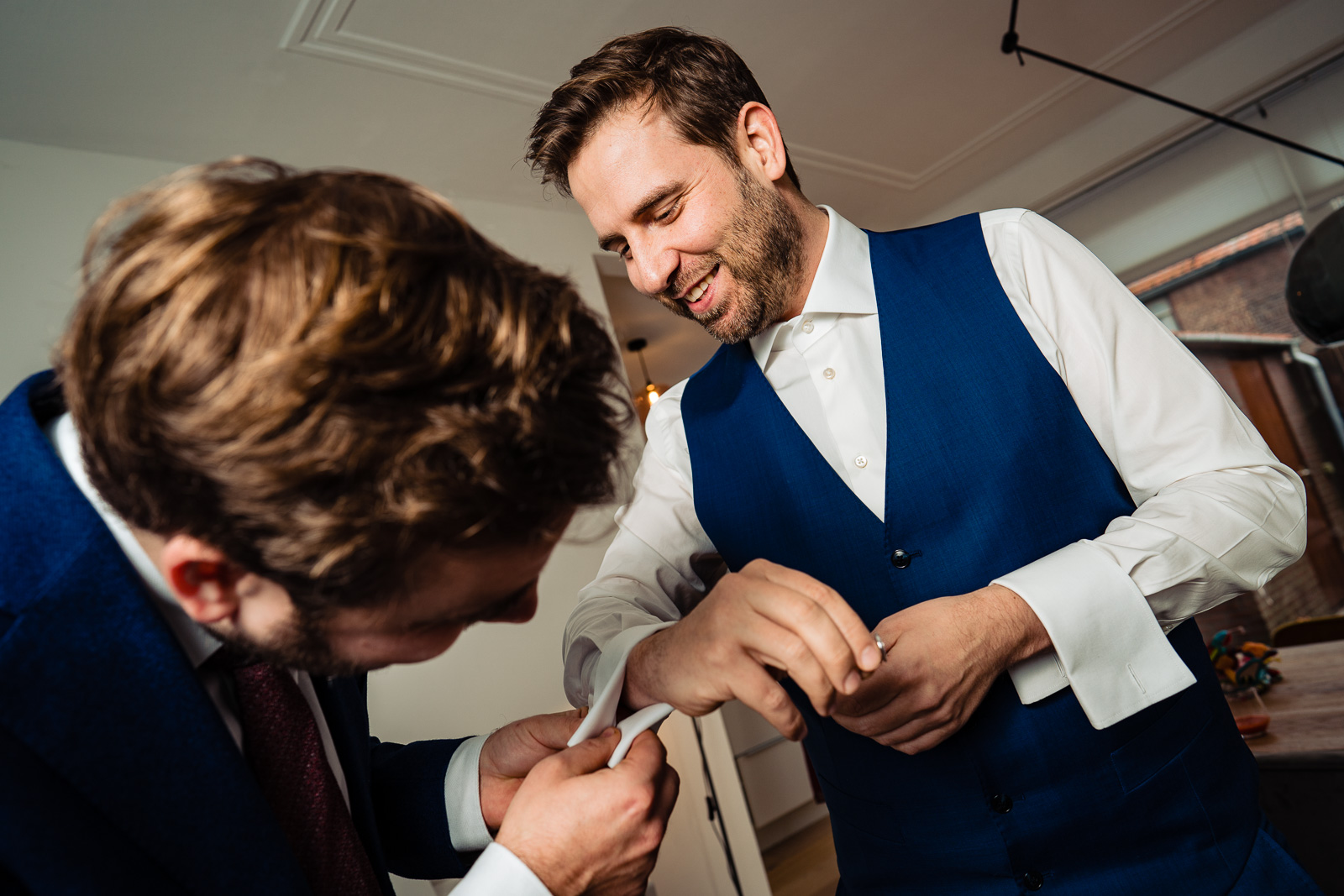 Trouwfotograaf Leiden bruidegom krijgt hulp met manchet knopen