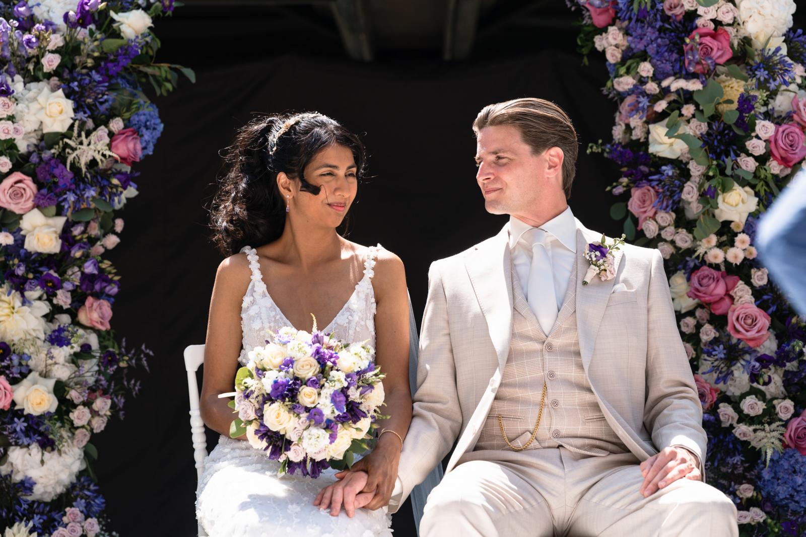 Trouwceremonie in kasteel bruid en bruidegom voor bloemenboog trouwfotograaf Paco van Leeuwen