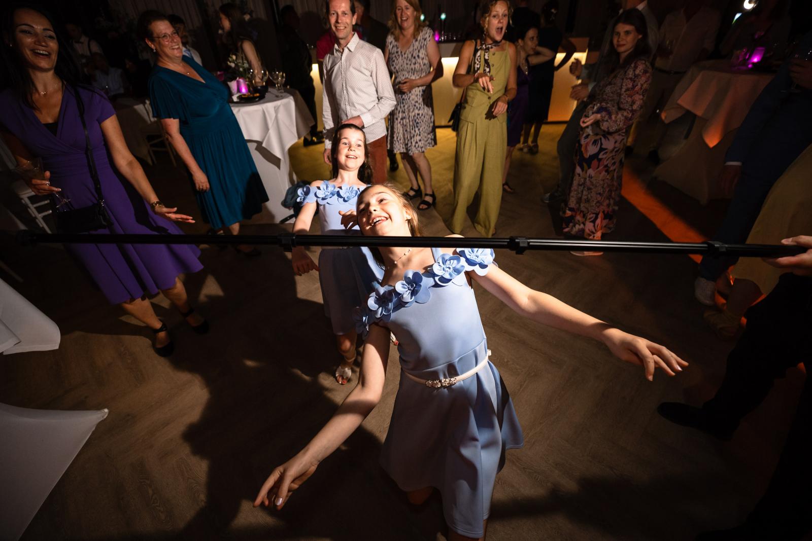 Limbo dansende bruidsmeisjes op huwelijksfeest in kasteel Trouwfotograaf Paco van Leeuwen