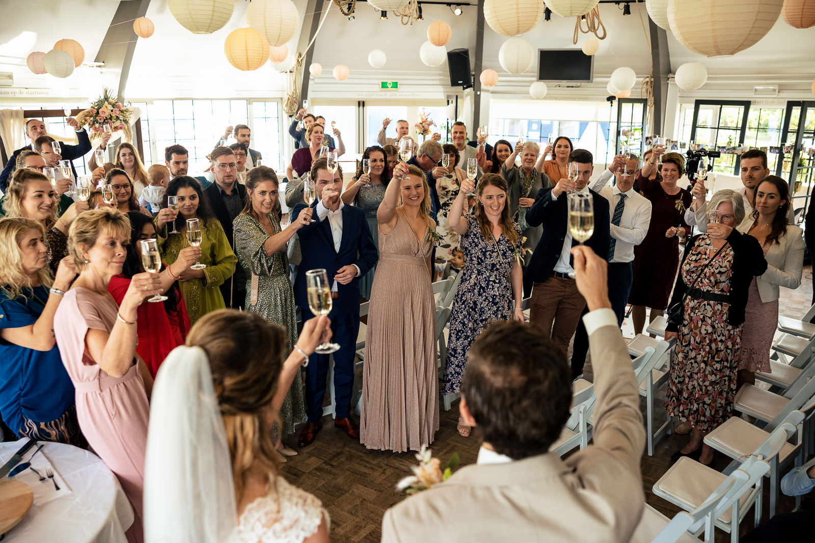 Herfstbruiloft bruiloft bruidspaar proost met alle gasten Trouwfotograaf Den Haag Paco van Leeuwen