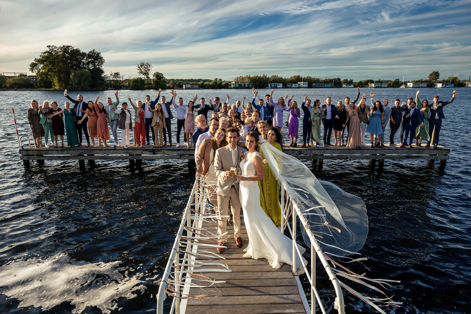Herfstbruiloft bruiloft groepsfoto met alle gasten aan het water Trouwfotograaf Den Haag Paco van Leeuwen