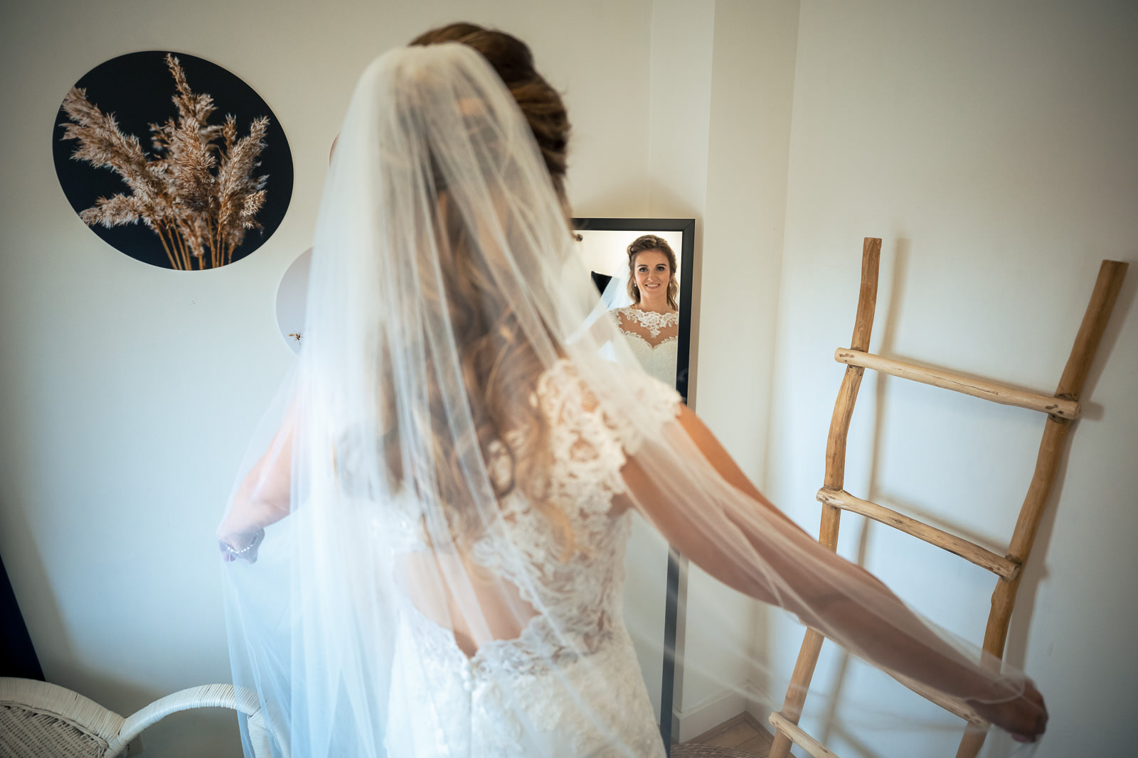Bruid bekijkt haar hele jurk en sluier in de spiegel Trouwfotograaf Den Haag Paco van Leeuwen