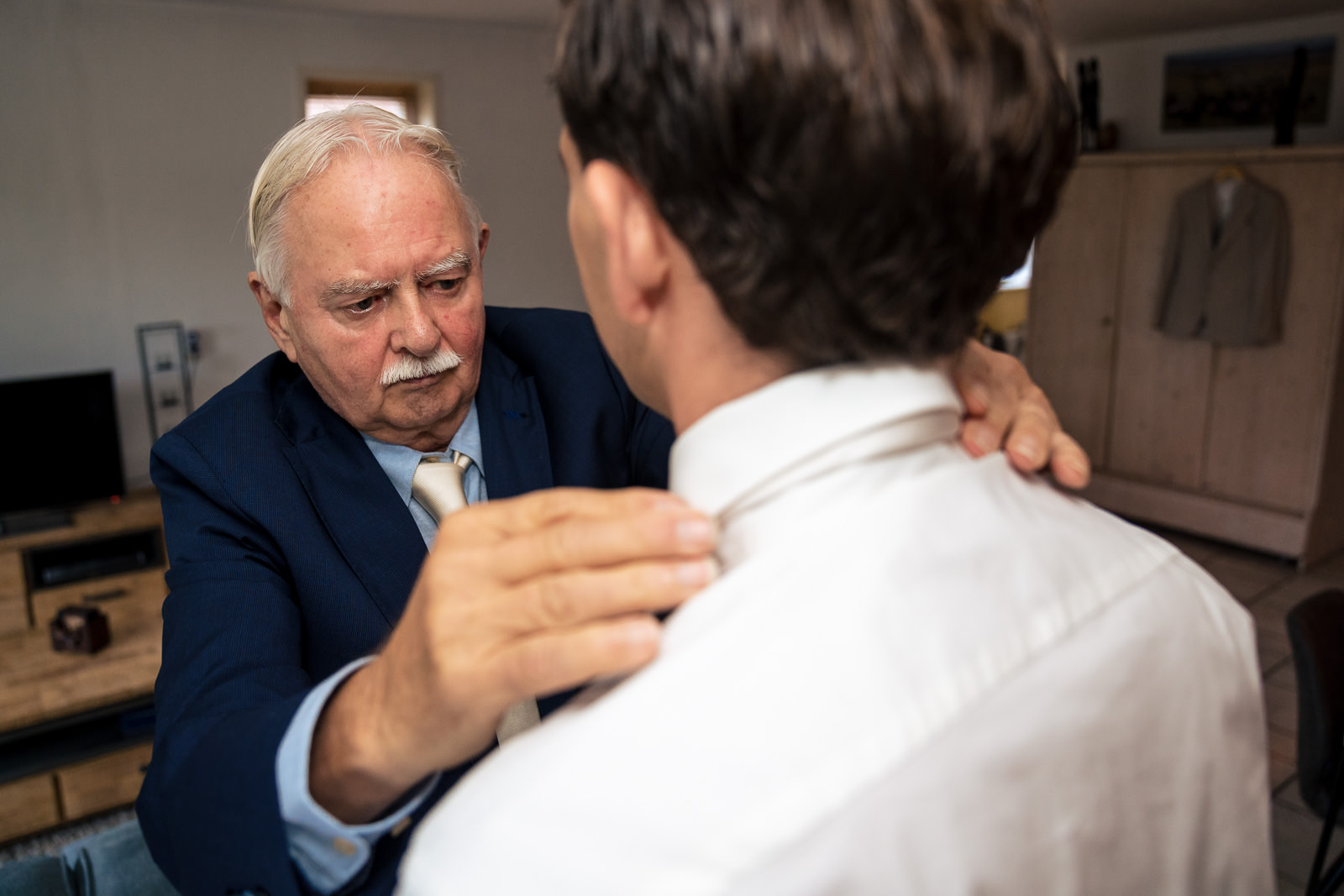 Vader helpt bruidegom met stropdas Trouwfotograaf Den Haag Paco van Leeuwen