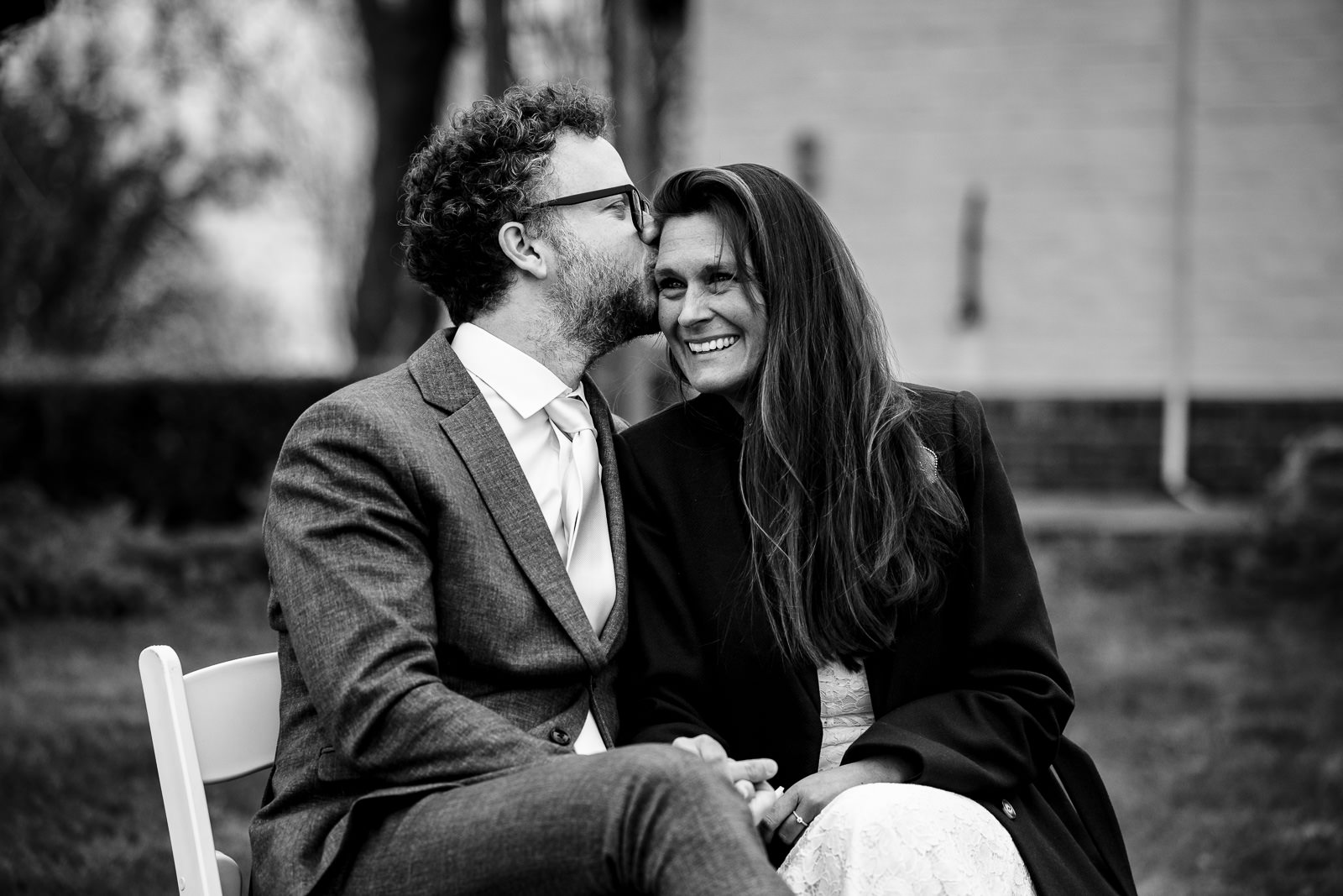 Trouwfotograaf Leeuwarden Friesland liefdevolle kus van de bruidegom aan bruid tijdens de trouwceremonie