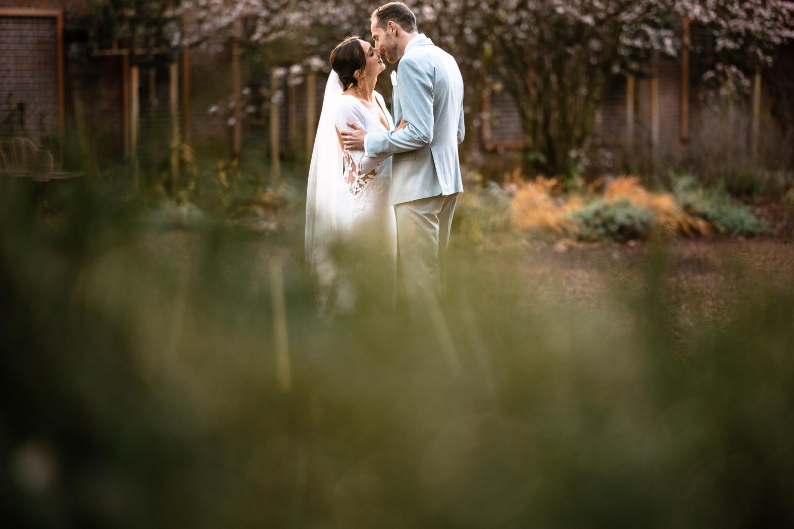 Bruidspaar deelt een intiem moment in de tuin van Het Spaansche Hof Den Haag – trouwfotografie Den Haag.