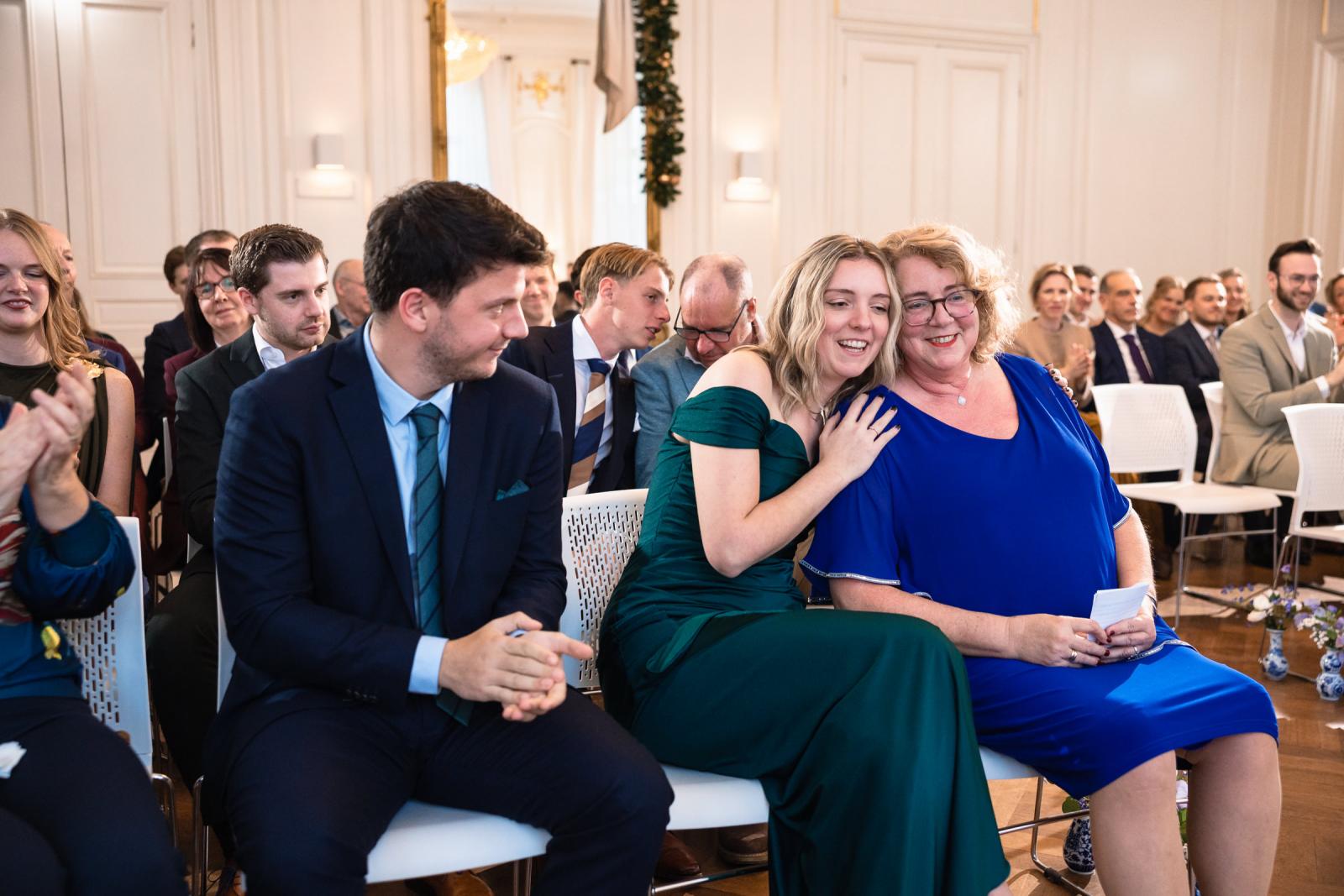 Gasten delen een warm moment tijdens ceremonie – sfeerimpressie bruiloft Spaansche Hof Den Haag.