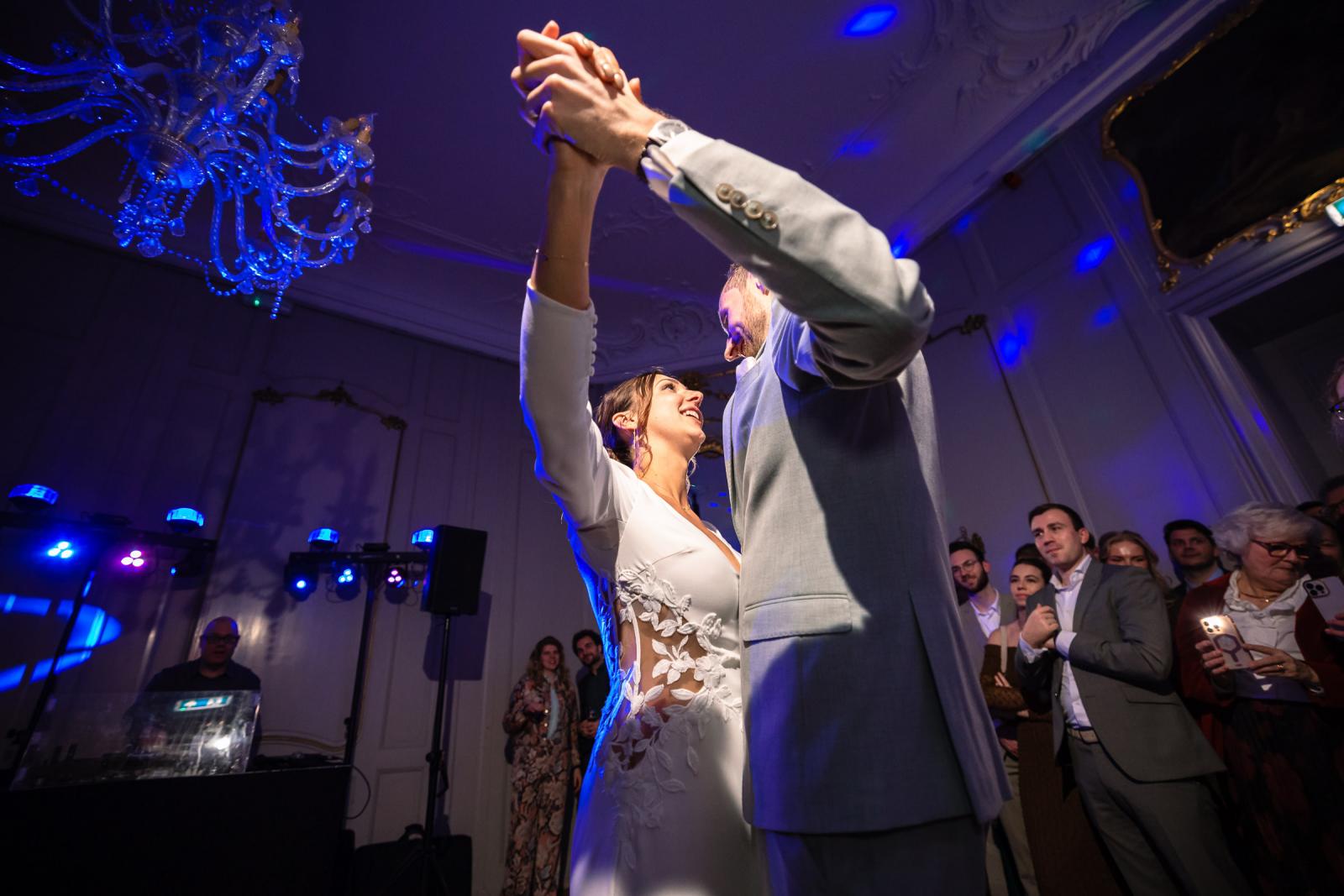 Bruidspaar danst samen, omringd door gasten – feestelijke sfeer Spaansche Hof Den Haag.