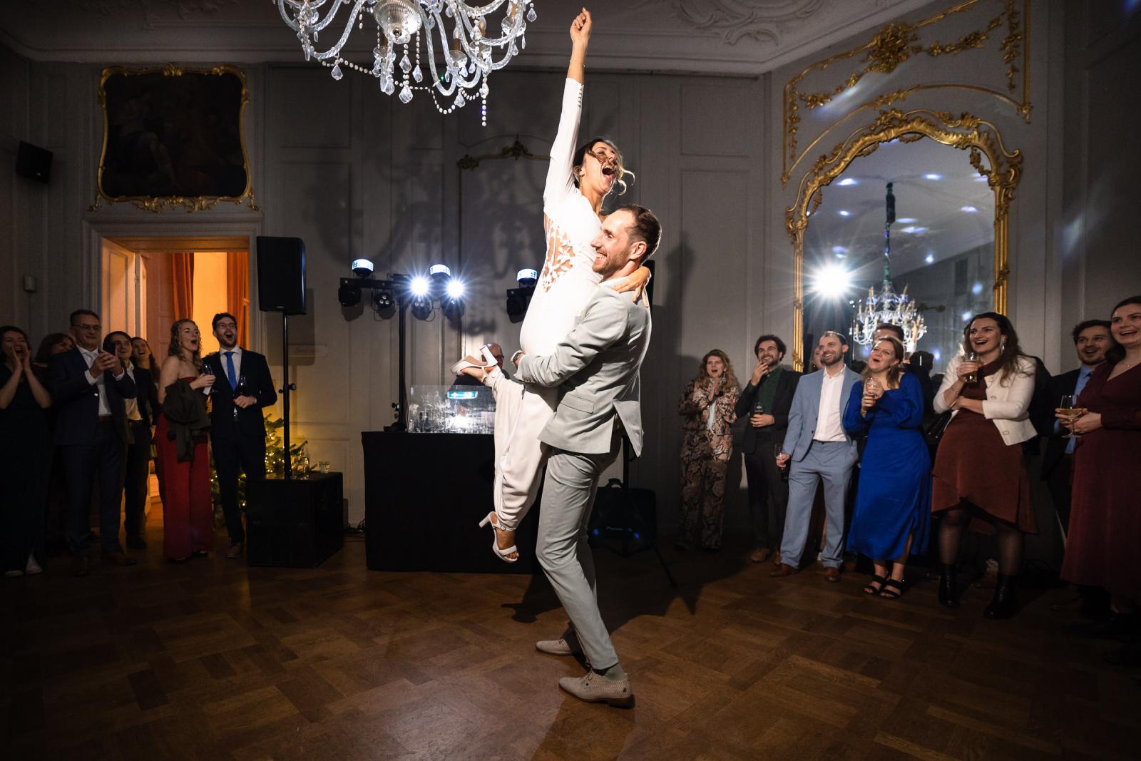 Bruidegom tilt bruid op tijdens spetterende dans – energiek trouwfeest Spaansche Hof Den Haag.