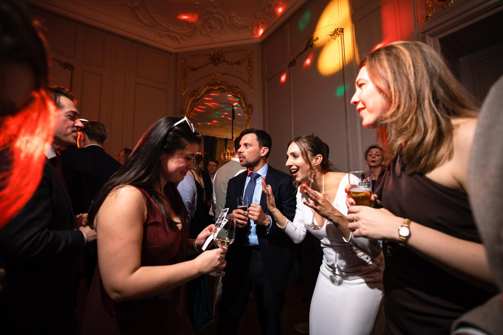 Bruid praat en lacht met gasten tijdens het feest – ongedwongen sfeer Spaansche Hof Den Haag.