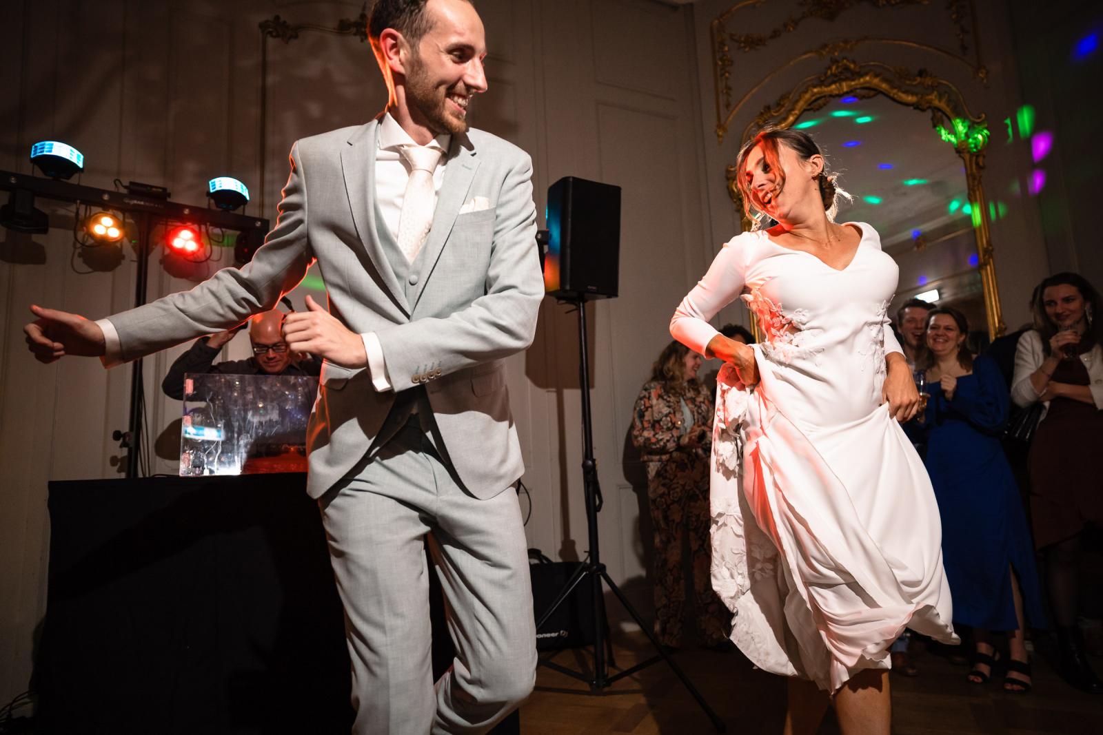 Bruidspaar swingt samen op de dansvloer – energieke trouwfoto Spaansche Hof Den Haag.