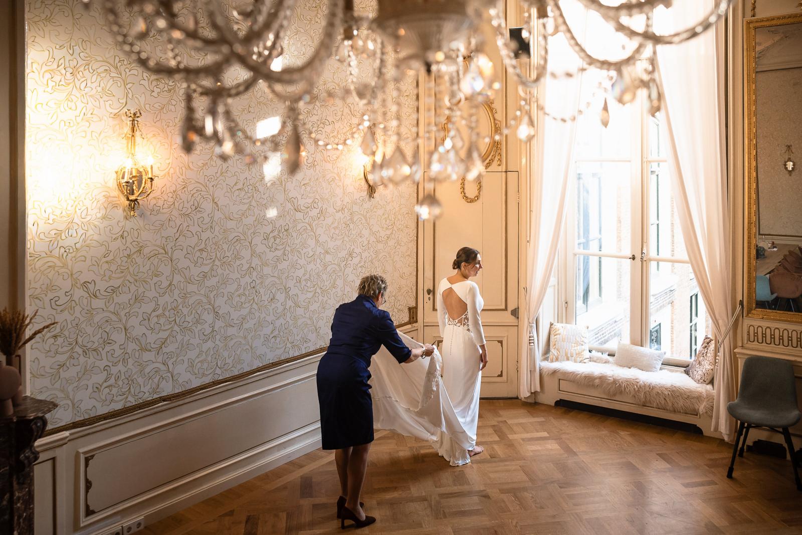 Overzicht van bruid in haar trouwjurk met sleep, vastgelegd in klassieke kamer van Het Spaansche Hof Den Haag.