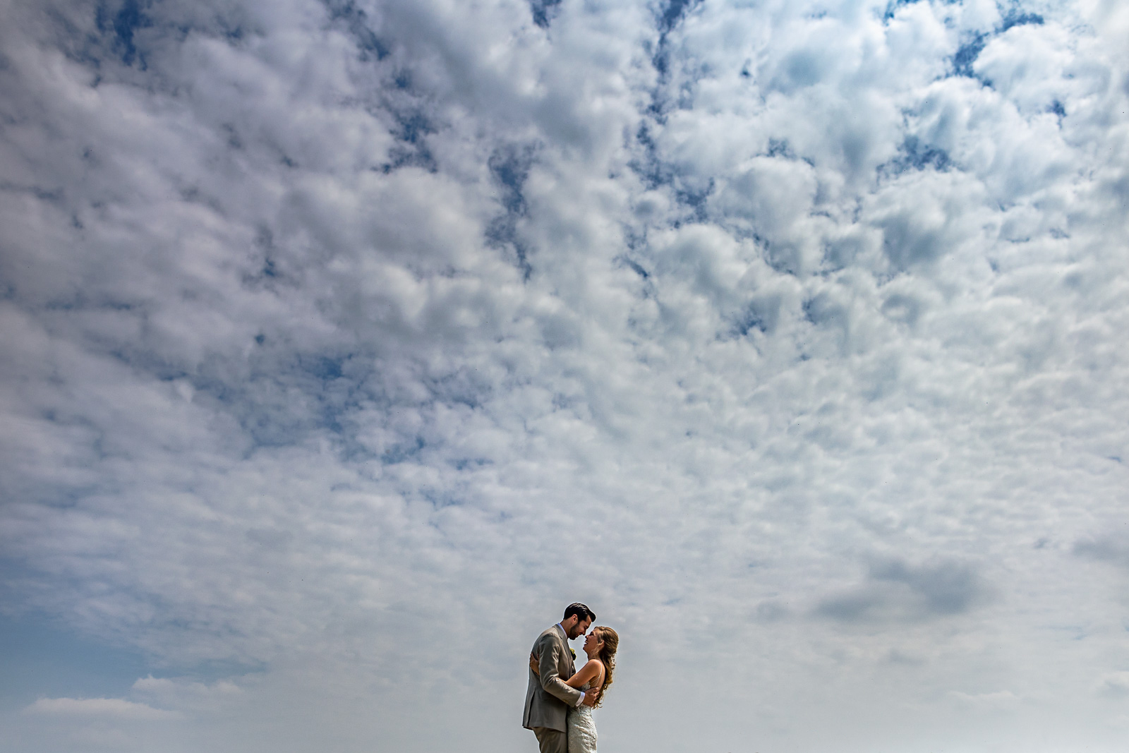 Bruidspaar onder een mooie bewolkte lucht te Rotterdam