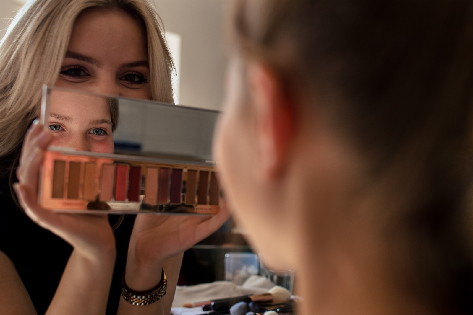 bruidsmeisje bekijkt haar make-up in de spiegel