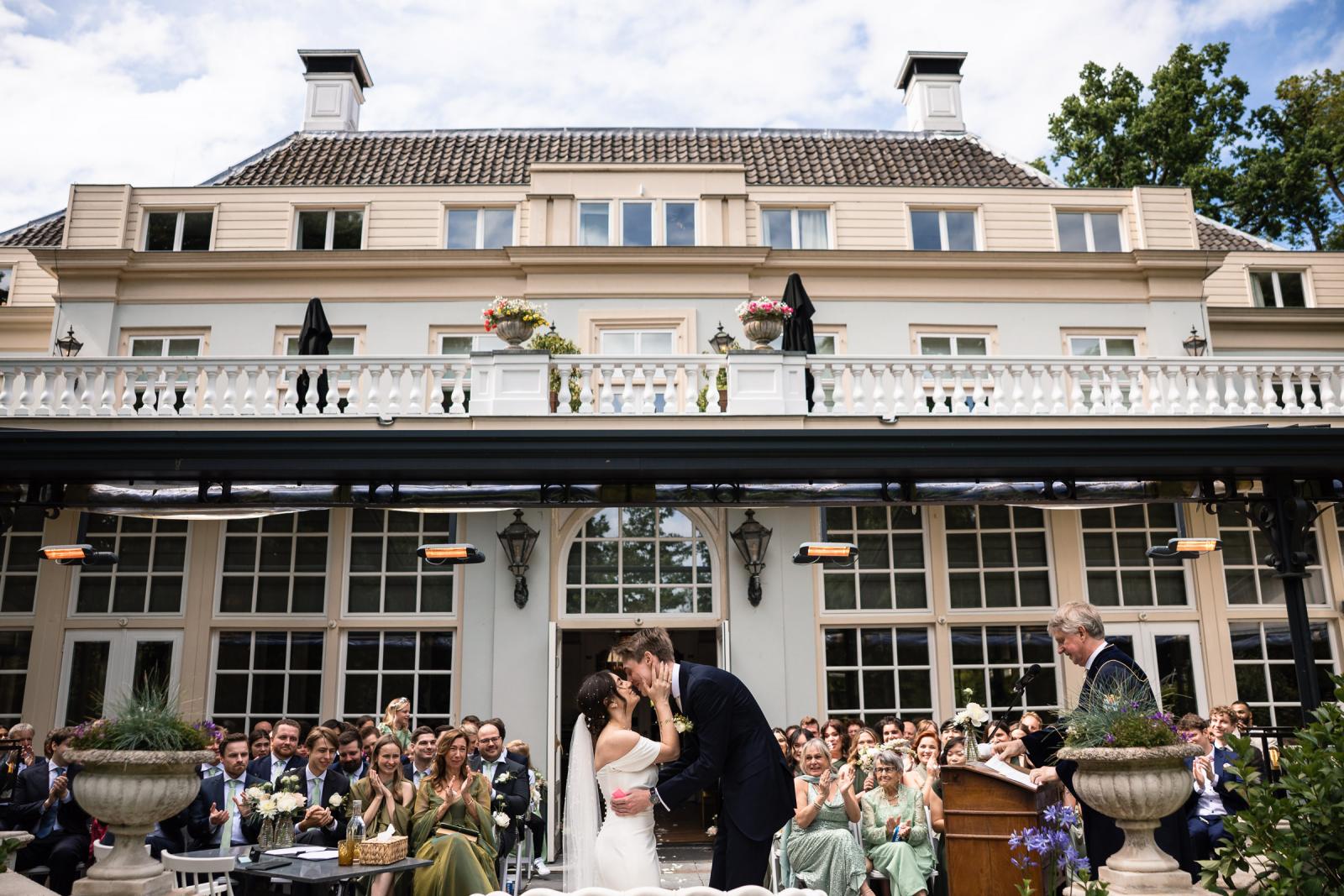 Eerste kus bruidspaar tijdens de ceremonie bij Central Park Voorburg
