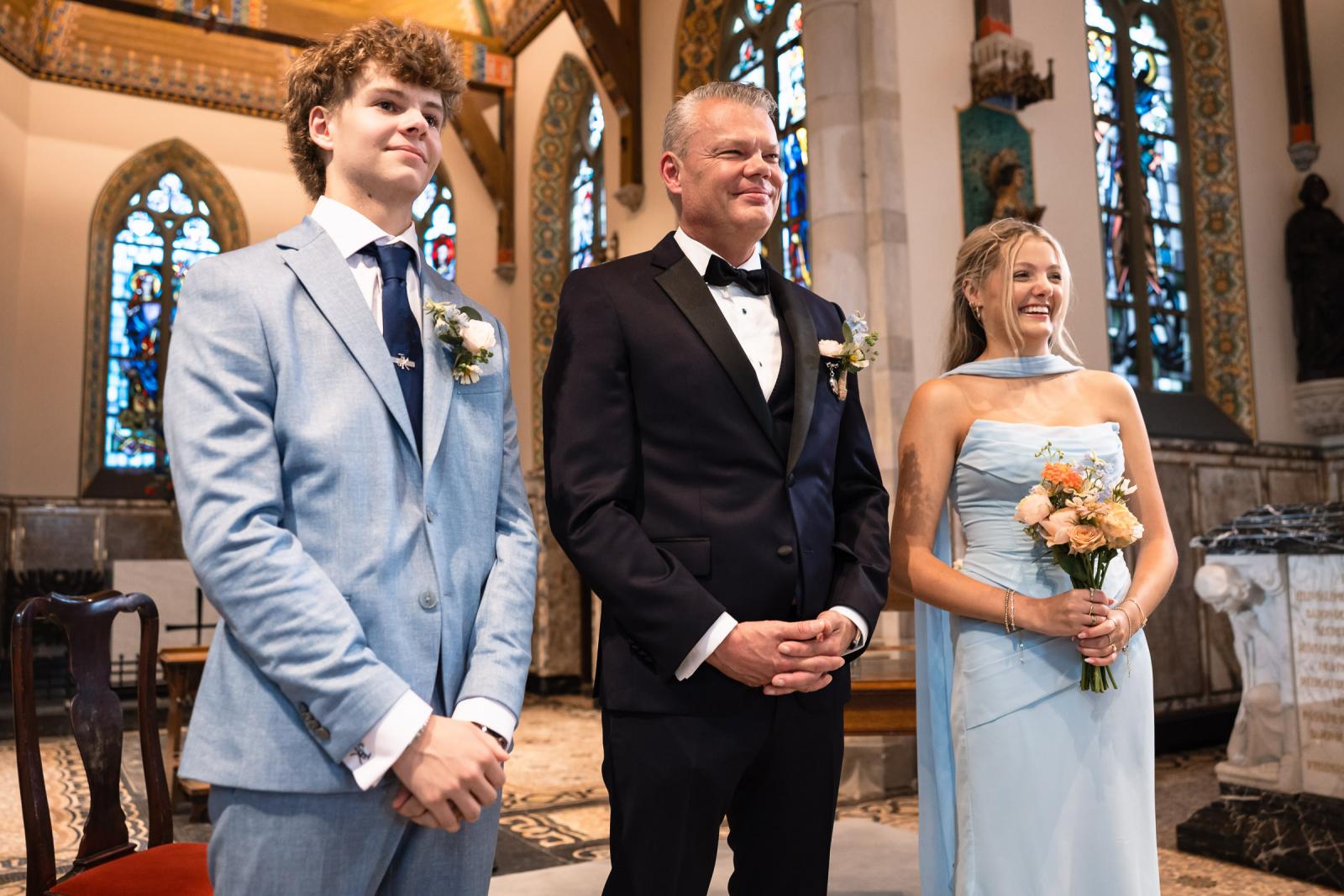 Bruidegom Mike straalt bij het zien van zijn bruid die naar hem toe loopt voor de ceremonie bij Kasteel de Haar