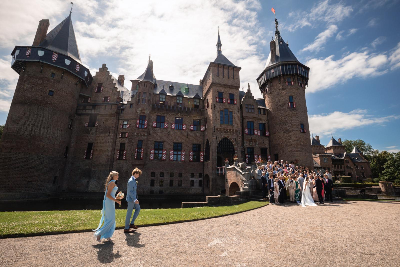Zoon en dochter lopen richting de grote groepsfoto voor het indrukwekkende en historische Kasteel de Haar.