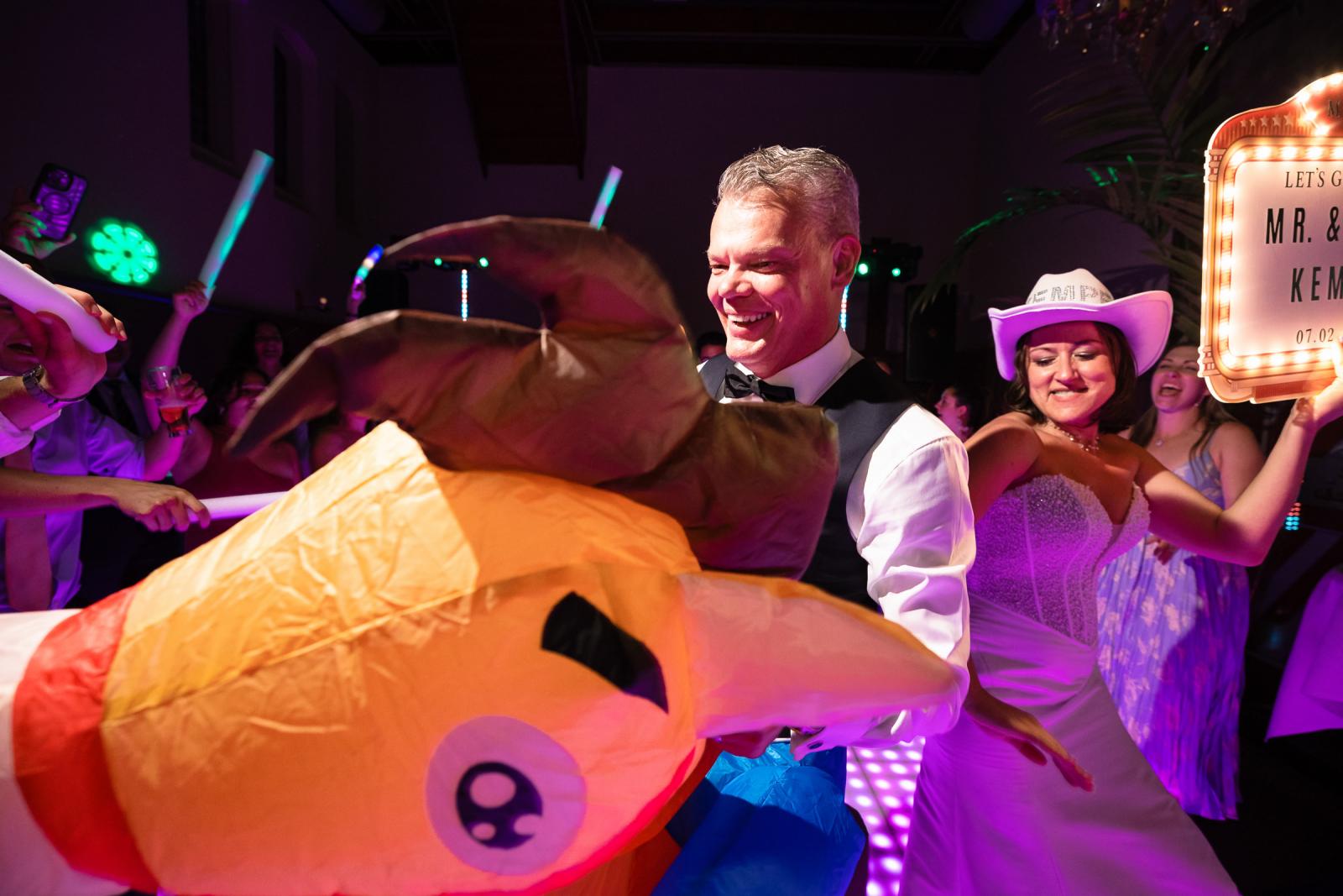 Bruidegom Mike op zijn opblaasbare paard en bruid Nadine met cowboyhoed feesten samen vol energie op de LED-dansvloer.