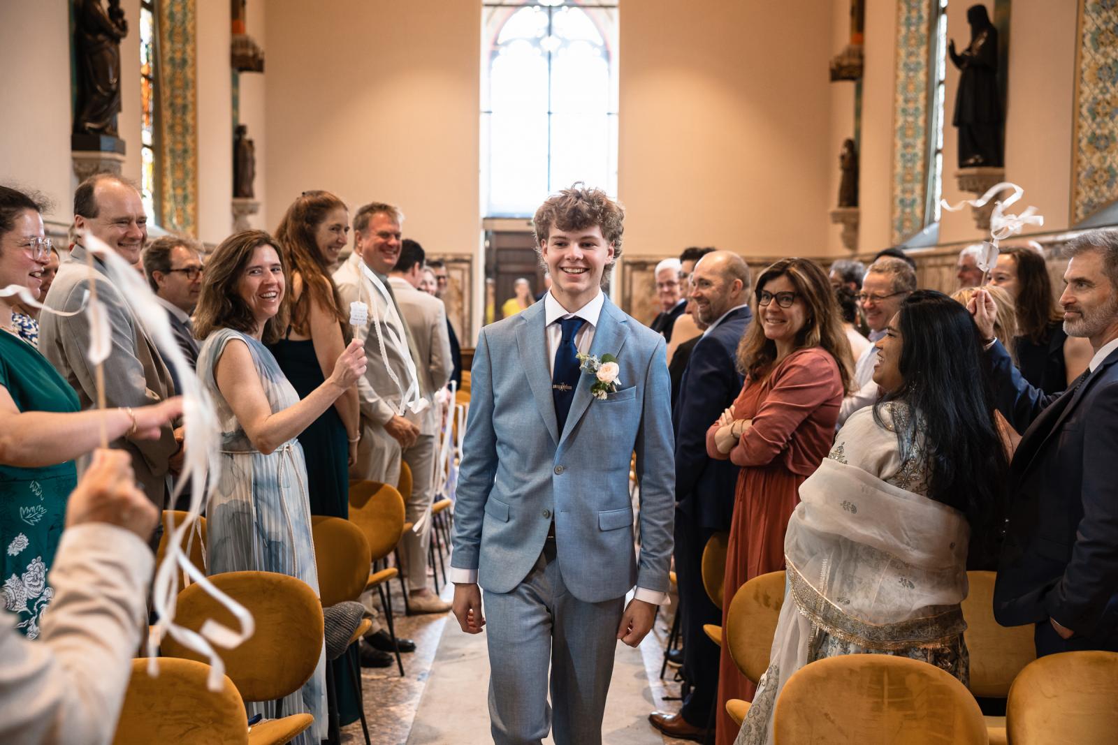 Zoon loopt glimlachend door het gangpad van de kapel van Kasteel de Haar