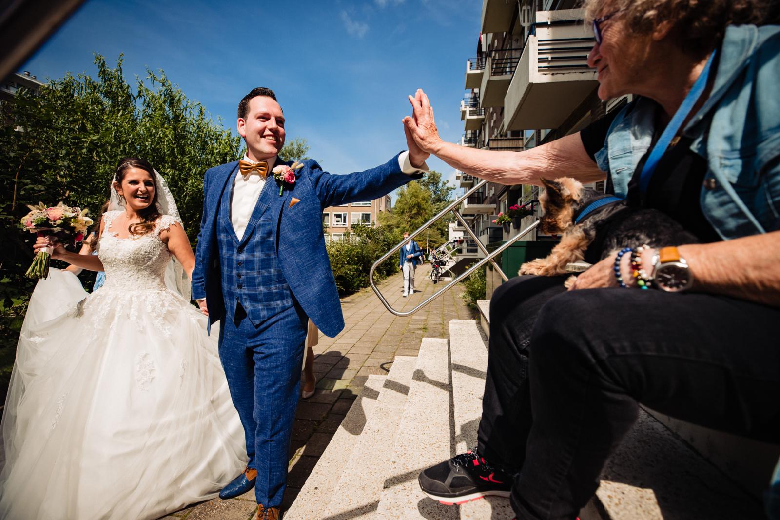 Bruid en bruidegom krijgen felicitaties van de buurvrouw