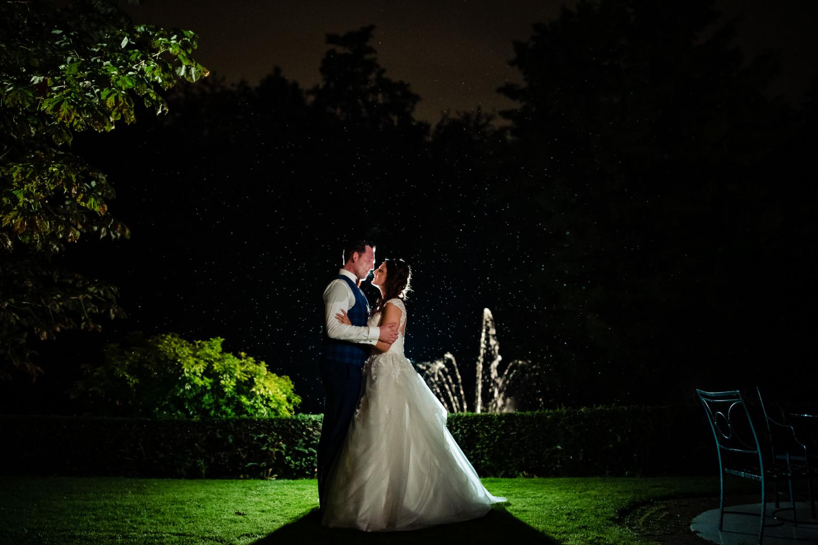 Foto van bruidspaar in de regen en in het donker door trouwfotograaf den haag