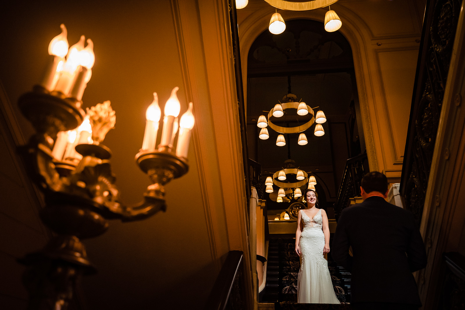 Bruid bovenaan de trap First look bruidspaar hotel Des Indes Trouwfotograaf Den Haag 