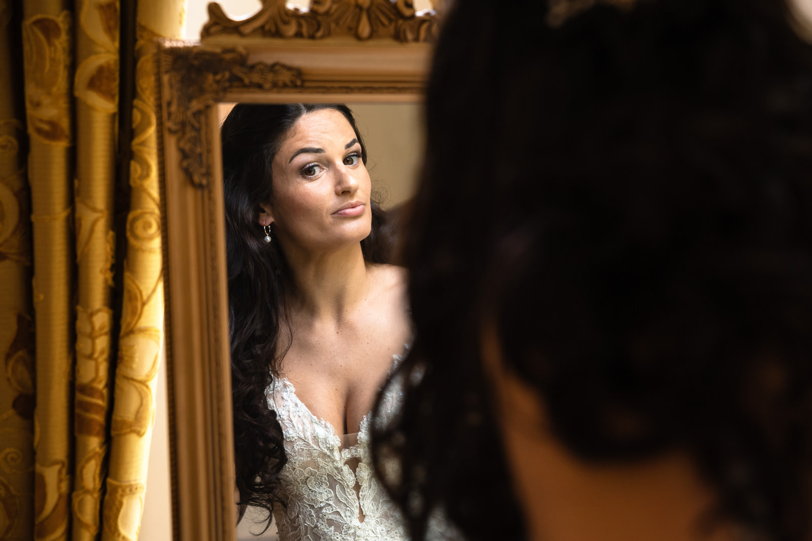 Bruid doet checkt haar make-up en haar in de spiegel bij kasteel de Wittenburg in Wassenaar