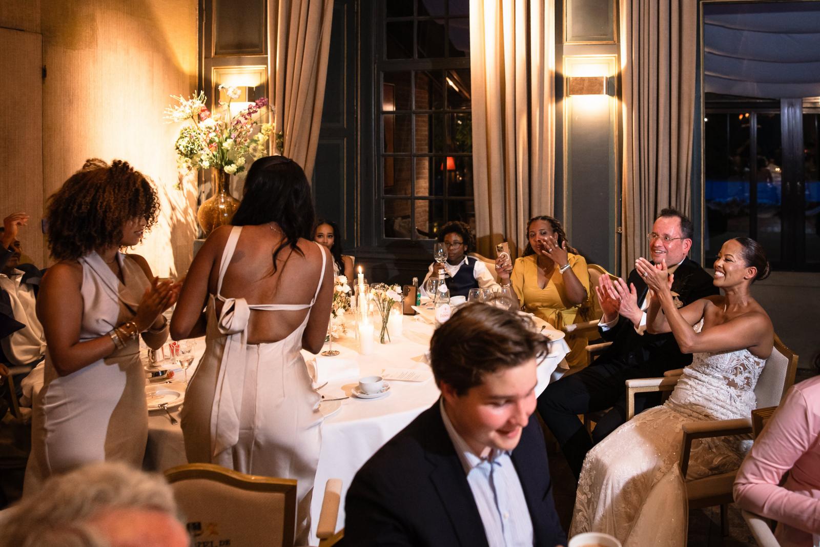 Bruidspaar Ronald en Tigist klapt vrolijk mee tijdens de speeches van de gasten aan de dinertafel.