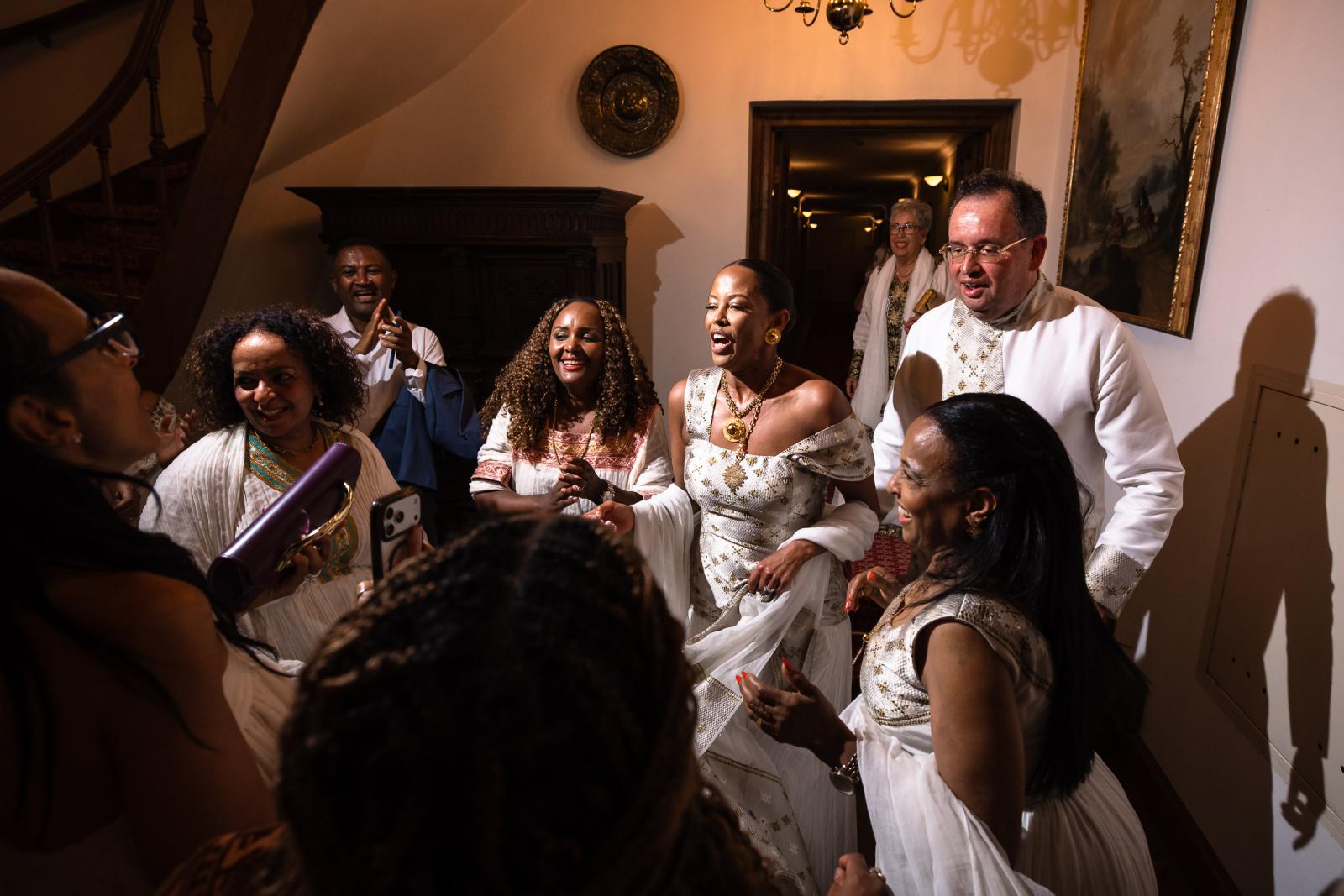 Vrolijke gasten zingen en dansen samen in de gang in traditionele Ethiopische witte kleding.