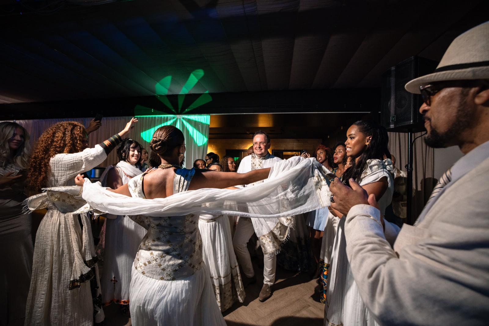 Bruid Tigist danst met een traditionele witte doek tijdens het Ethiopische avondfeest.