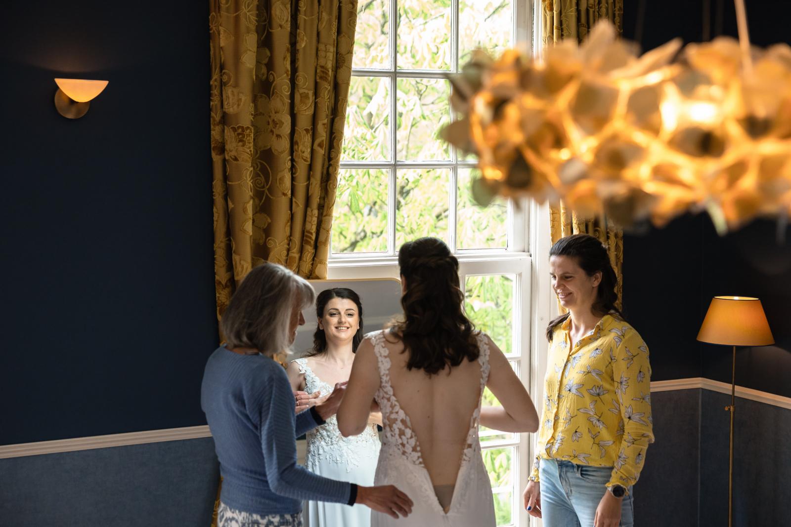 Bruid maakt zich klaar bij raamlicht tijdens voorjaarsbruiloft in Kasteel de Wittenburg, Wassenaar