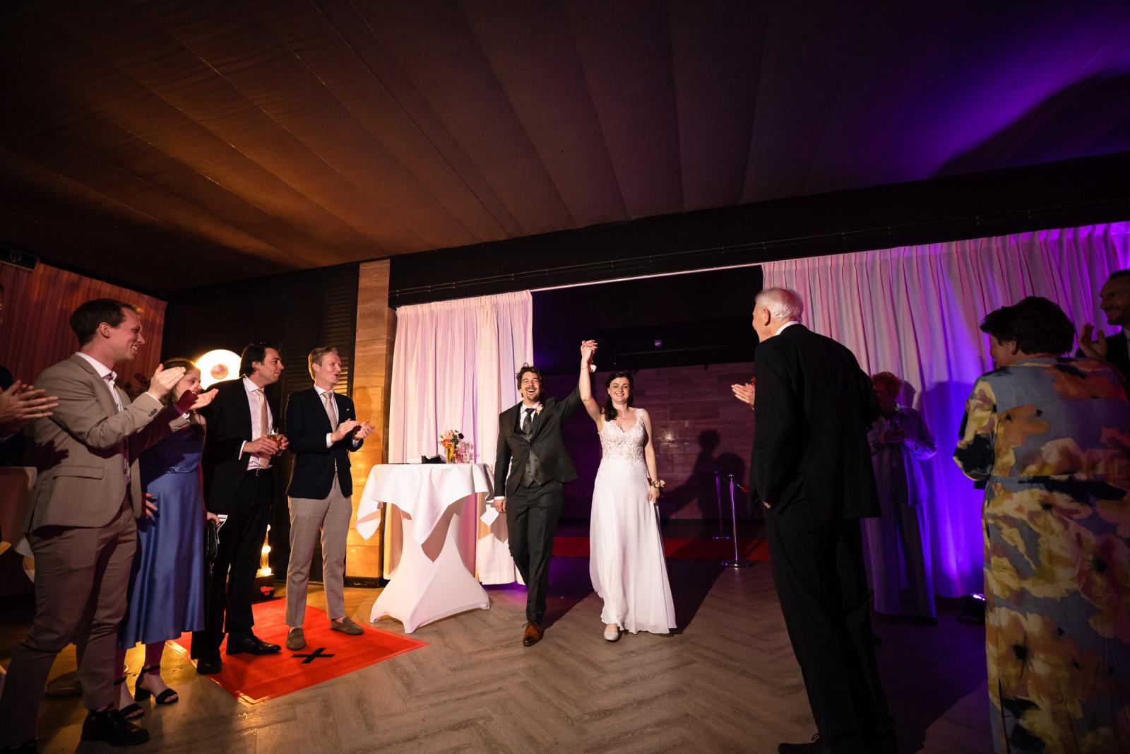 Entree van bruidspaar op feestavond, gasten applaudisseren bij Kasteel de Wittenburg